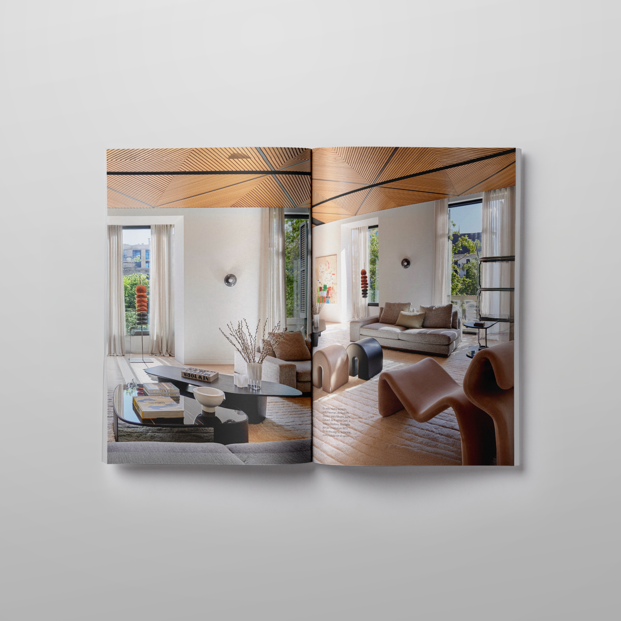 Double-page spread showing the main living area of the Passeig de Gràcia apartment, designed by LUV Studio, with bespoke ceiling details and contemporary furniture.